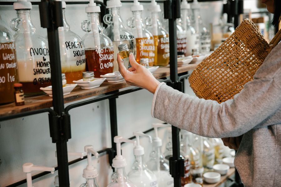 Customer examining a glass jar of refillable shampoo