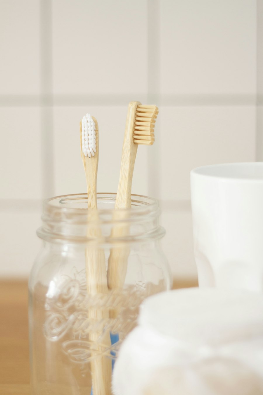 Two bamboo toothbrushes on a light background