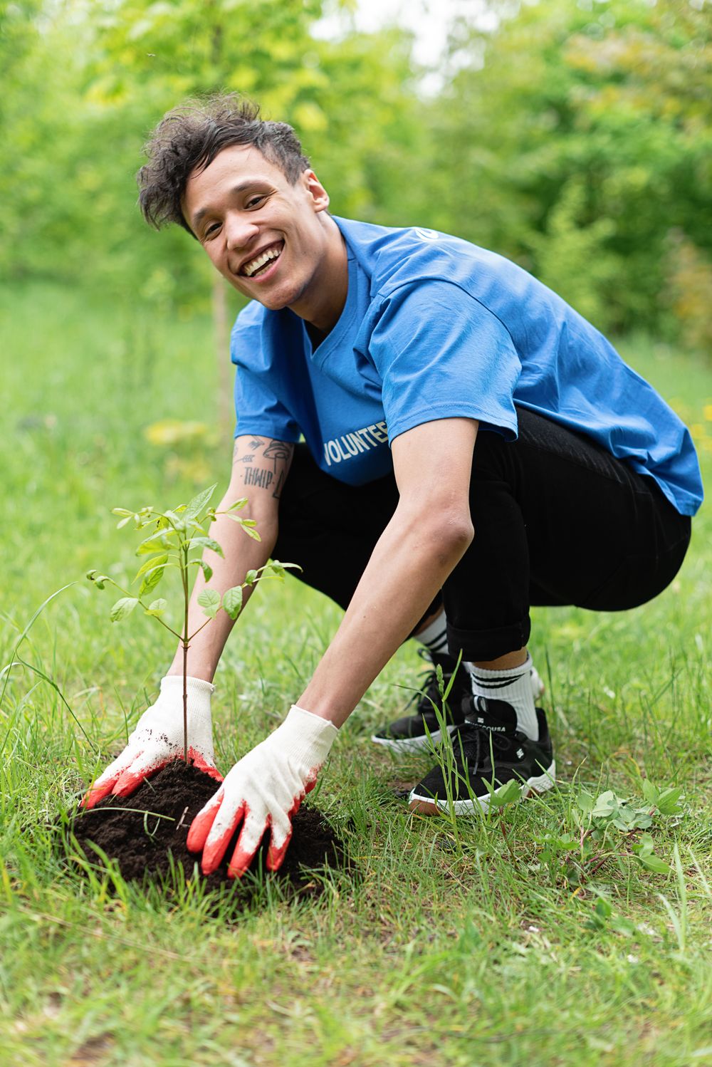 Volunteer smiling after planting a young tree
