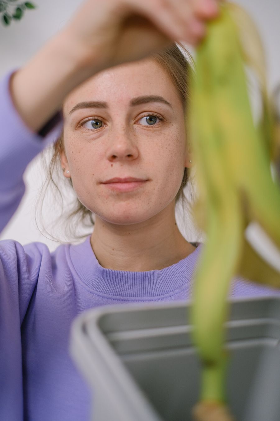 Woman holding a banana peel over a compost bin